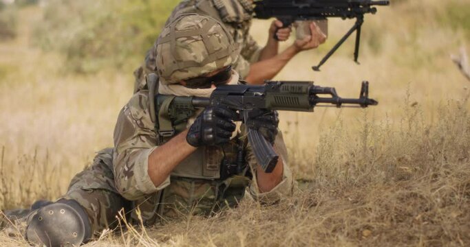 Unrecognizable soldier firing rifle during battle