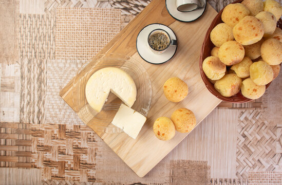 Minas cheese, cup of coffee and cheese bread from Brazil, arranged on a table with beige tablecloth and gray fudo, Top view.