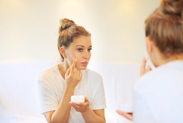 Obraz na płótnie Canvas Magic anti-aging cream.Applying the cream. woman moisturizing face mask. Cosmetology and skin care concept.