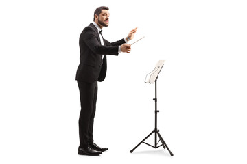 Full length profile shot of a musical conductor with a baton performing