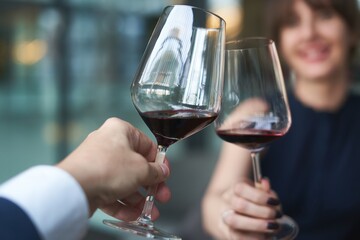Happy couple drinking red wine. Selective focus on wine glass.