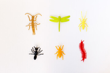 plastic toy insect on the white background, orange beetle tick, green caterpillar, red centipede or...