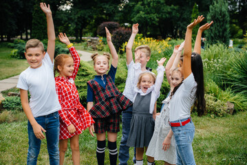 Fototapeta premium A group of children run around, have fun and play as a larger team in the summer in the Park. Happy childhood