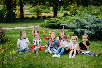 A teacher teaches a class of children in an outdoor Park. Back to school, learning during the pandemic