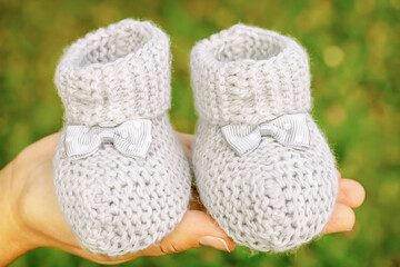 small knitted booties for newborn in the palm of your hand