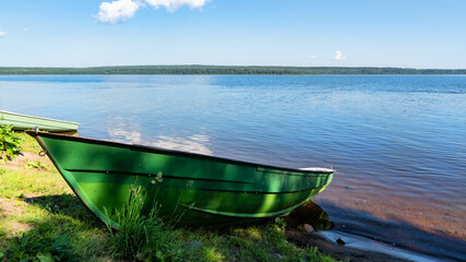 Naklejka na ściany i meble alone boat on the shore of lake Sukhodolskoye in the village of Losevo
