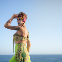 Beautiful and sensual belly dancer woman wearing African ethnic clothes and doing her dance in...