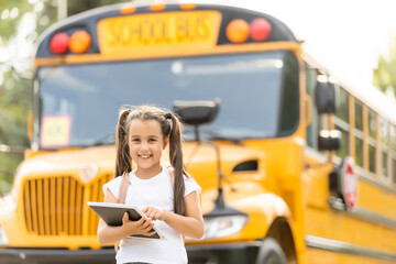 Girl with backpack near yellow school bus. Transport for students