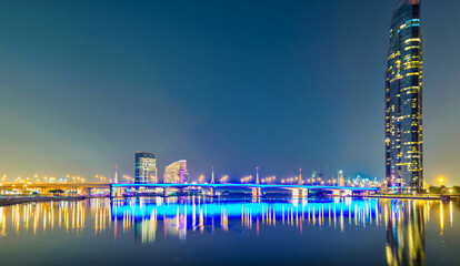Light illuminated bridge with business tower at night in Dubai