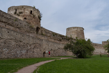 Fototapeta na wymiar Ryabinovka Tower and Vyshka Tower with wall in medieval Izborsk fortress. Izborsk, Pskov region, Russia.