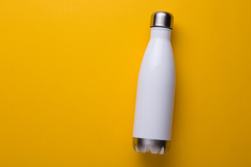 White reusable metal bottle on yellow background