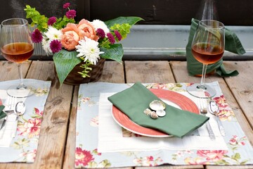 Outdoor cafe restaurant setting for warm summer evening romantic dinner dates in sheltered patio with beautiful table decor and wine