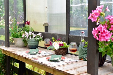 Outdoor cafe restaurant setting for warm summer evening romantic dinner dates in sheltered patio with beautiful table decor and wine