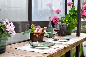 Outdoor cafe restaurant setting for warm summer evening romantic dinner dates in sheltered patio with beautiful table decor and wine