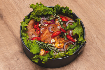 Raw meat. Marbled beef steak in metal baking dish. Vegetables on table. Organic food. Flat lay. Dark Wooden background