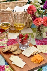 Outdoor summer gourmet picnic basket foods in beautiful romantic garden setting for special staycation relaxing meal on warm evening to share with someone special