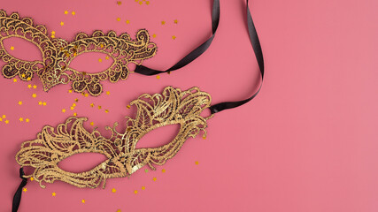 Golden carnival masks and confetti on pastel pink background. Flat lay, top view. Christmas, Masquerade concept