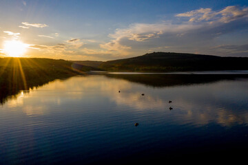 aerial view of fisherman at the boat on golden sunset river. silhouette of fishermen with his boat, Fisherman life style