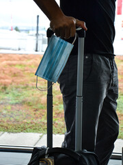 Man traveling during covid19 epidemic. Passport and protective face mask mandatori in airport. Coronavirus new travel concept.
