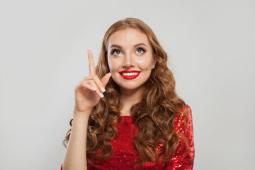 Beautiful young woman fashion model pointing up on white background