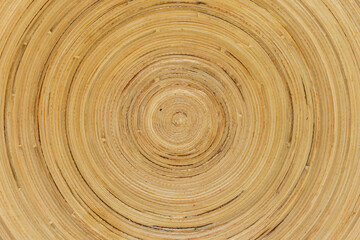 Fototapeta na wymiar Abstract circular pattern on wooden bowl close up. Concentric texture of wood. Round pattern of wooden bamboo bowl