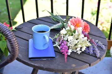 Relaxing outdoor balcony space for working from home or reading on warm seasonal days in summer with beautiful landscaped gardens in background for mindfulness space