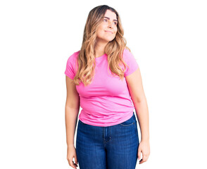Fototapeta premium Young caucasian woman wearing sportswear looking away to side with smile on face, natural expression. laughing confident.