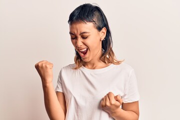 Young woman wearing casual clothes celebrating surprised and amazed for success with arms raised and eyes closed