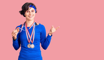 Beautiful young woman with short hair wearing winner medals smiling happy pointing with hand and finger to the side