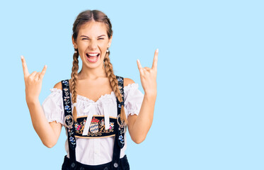 Beautiful caucasian woman with blonde hair wearing octoberfest traditional clothes shouting with...