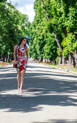 Fototapeta na wymiar Young Woman Walking in a Park