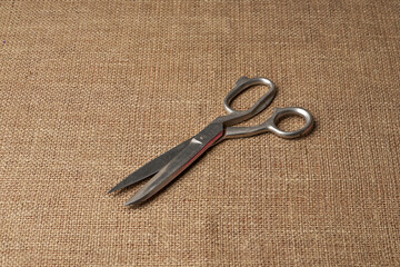 Old steel tailor scissors on burlap