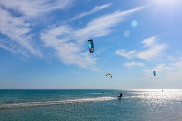 a kitesurfer surfing on the smooth azure water. recreational sport. A Man Rides A Kiteboarding In The Sea Water. extreme sport. Jump