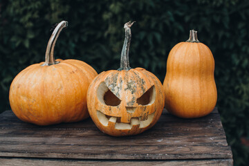 Spooky Jack-o-lantern face on a pumpkin for Halloween on wooden table. Background, copy space, close up. All hallows eve Halloween party decoration. Trick or treat concept.