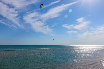 a kitesurfer surfing on the smooth azure water. recreational sport. A Man Rides A Kiteboarding In The Sea Water. extreme sport. Jump