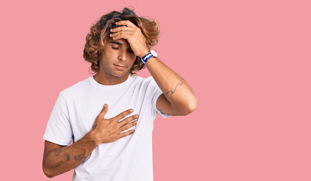 Young hispanic man wearing casual white tshirt touching forehead for illness and fever, flu and cold, virus sick