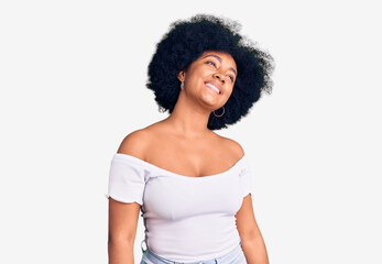 Fototapeta na wymiar Young african american girl wearing casual clothes looking away to side with smile on face, natural expression. laughing confident.