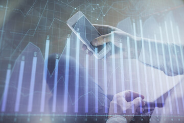 Double exposure of man's hands holding and using a digital device and forex graph drawing. Financial market concept.