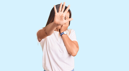 Beautiful caucasian woman wearing casual white tshirt covering eyes with hands and doing stop gesture with sad and fear expression. embarrassed and negative concept.
