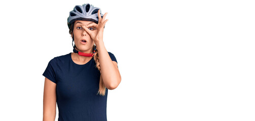 Fototapeta na wymiar Beautiful caucasian woman wearing bike helmet doing ok gesture shocked with surprised face, eye looking through fingers. unbelieving expression.