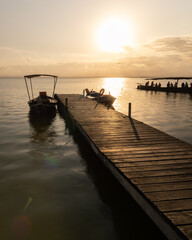 
Jetty in the lagoon of Valencia in the golden hour. The sunset gives warm touches to the image. The walkway is made of wood.