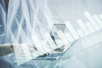 Double exposure of financial graph sketch hologram and woman holding and using a mobile device. Stock exchange concept.