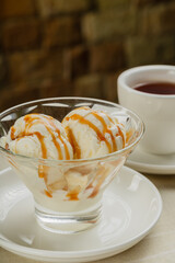 White ice cream in a glass glass with caramel.