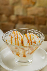 White ice cream in a glass glass with caramel.