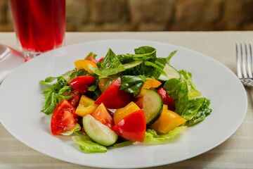 Summer fresh salad of tomato cucumber leaves lettuce.
