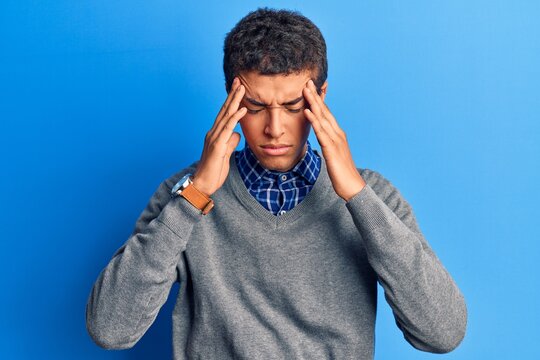 Young african amercian man wearing casual clothes suffering from headache desperate and stressed because pain and migraine. hands on head.