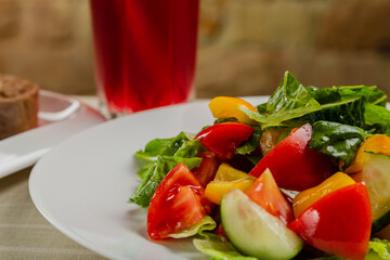 Summer fresh salad of tomato cucumber leaves lettuce.