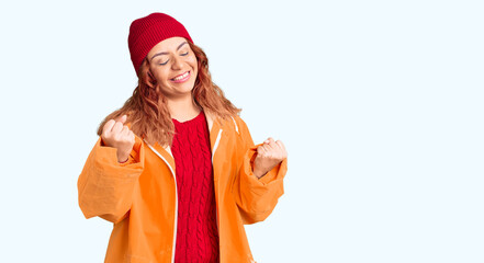 Fototapeta premium Young latin woman wearing winter casual clothes very happy and excited doing winner gesture with arms raised, smiling and screaming for success. celebration concept.