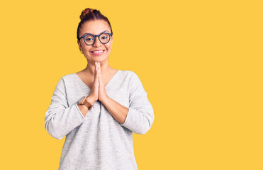 Young latin woman wearing casual clothes praying with hands together asking for forgiveness smiling confident.