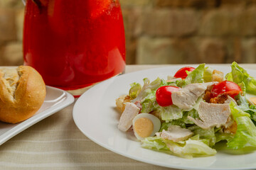 Fresh caesar salad in a white plate on the table.